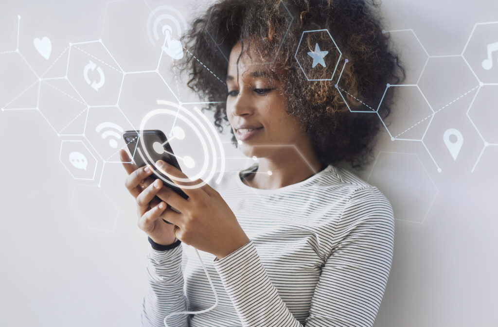 Cheerful black woman texting on her phone